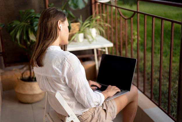 Frau in der Quarantäne, die zu Hause am Laptop arbeitet