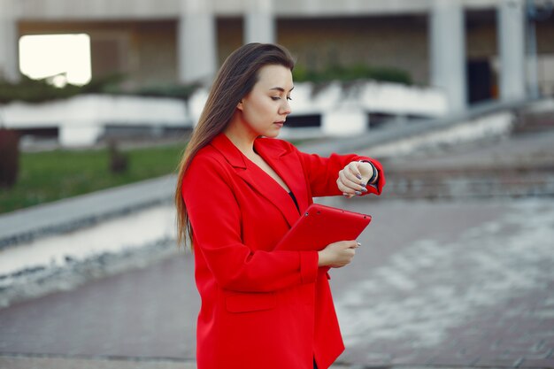 Frau in der roten Jacke unter Verwendung einer Tablette