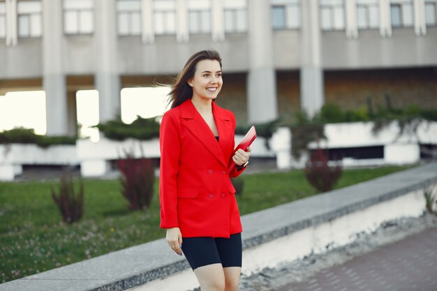 Frau in der roten Jacke unter Verwendung einer Tablette