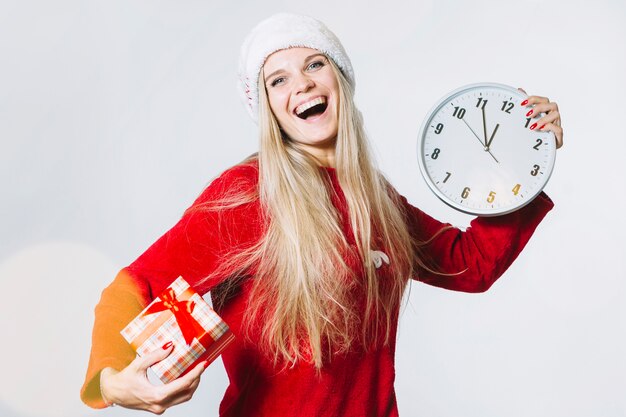 Frau in der roten Kleidung mit Uhr und kleiner Geschenkbox