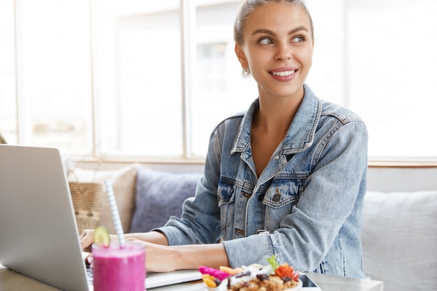 Frau in der stilvollen Jeansjacke im Coffeeshop