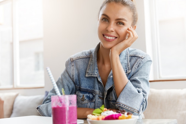 Frau in der stilvollen Jeansjacke im Coffeeshop