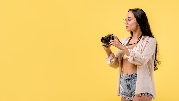 Kostenloses Foto frau in der strandkleidung, die fotokamera hält und foto macht