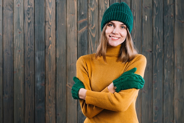 Frau in der Strickjacke, die Arme auf Kasten kreuzt