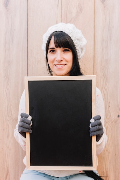 Kostenloses Foto frau in der strickjacke, die tafel hält