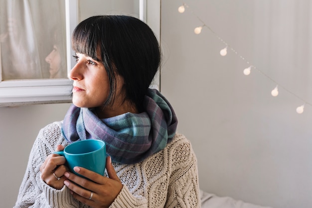 Frau in der Strickjacke mit Cup