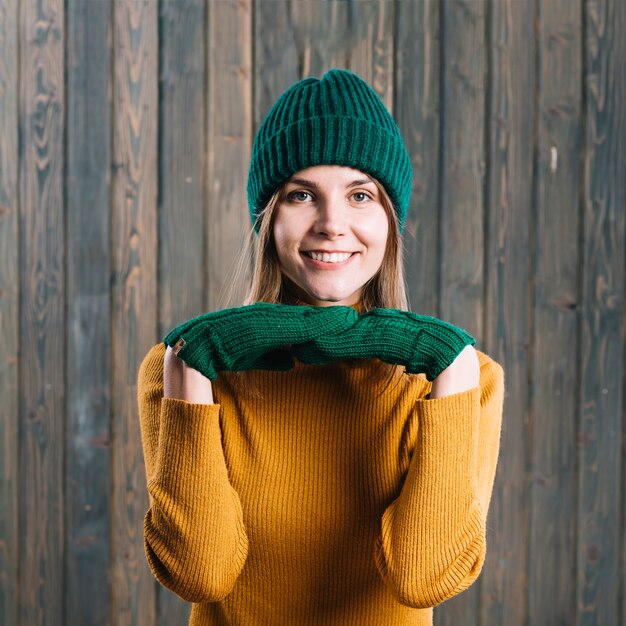 Frau in der Strickjacke mit den Händen unter dem Kinn