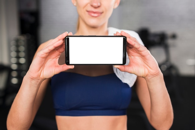 Frau in der Turnhalle mit Smartphoneschablone