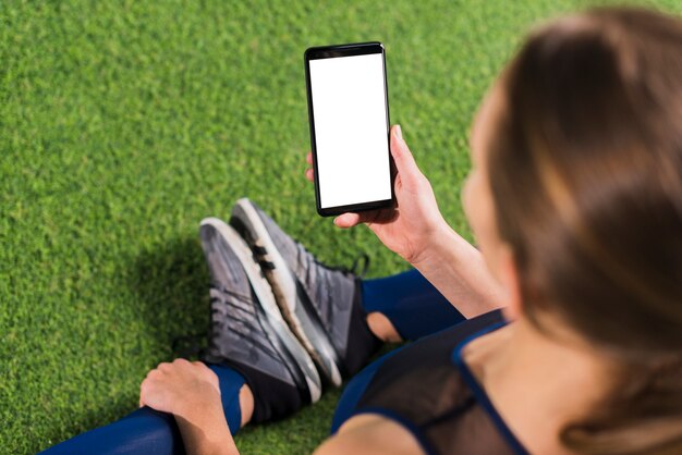 Frau in der Turnhalle mit Smartphoneschablone