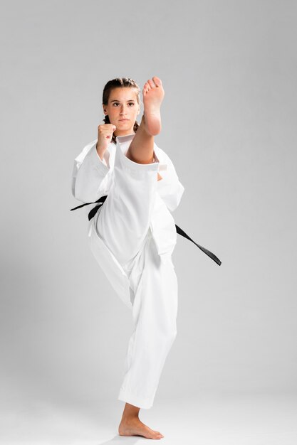 Frau in der Uniform der Kampfkünste Karate ausübend