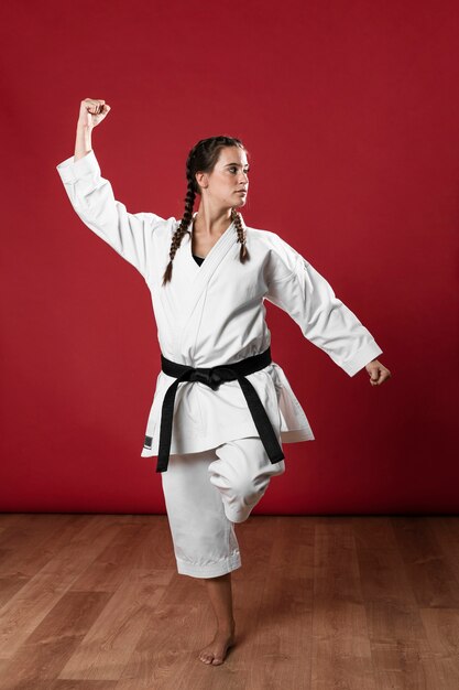 Frau in der Uniform der Kampfkünste Karate ausübend