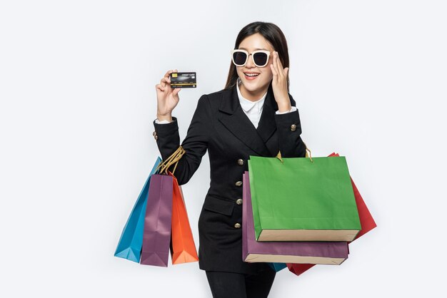 Frau in dunkler Brille tragen, einkaufen gehen, Kreditkarten und viele Taschen tragen