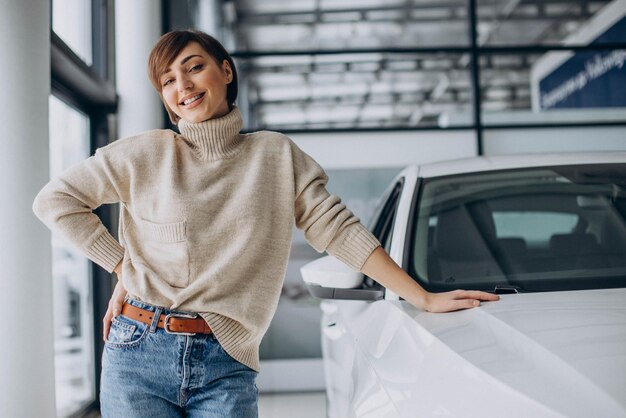 Frau in einem Autohaus, die ein neues Auto auswählt