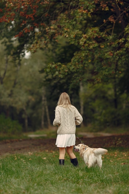 Frau in einem braunen Pullover. Dame mit einem Labrador