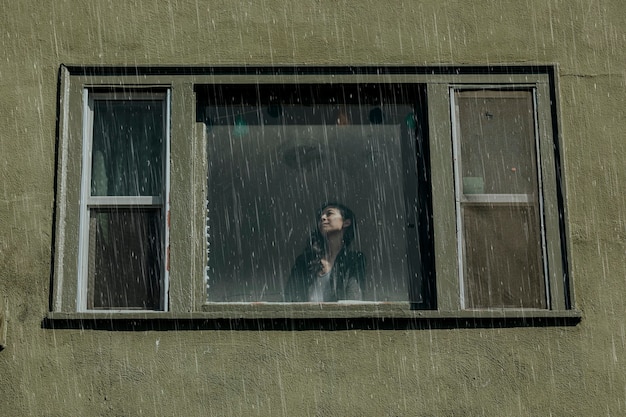 Frau in einem Haus an einem regnerischen Tag