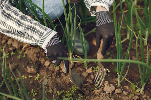 Frau in einem Hut, der in einem Garten arbeitet