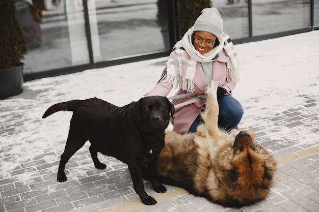 Frau in einem rosa Mantel mit Hunden