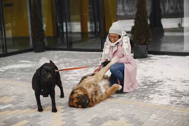 Frau in einem rosa Mantel mit Hunden