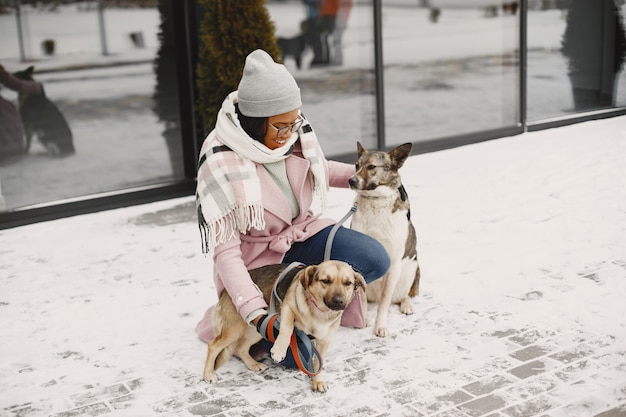 Frau in einem rosa Mantel mit Hunden