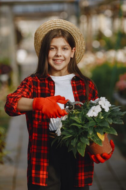 Frau in einem roten Hemd. Arbeiter mit Blumenstielen. Tochter mit Pflanzen