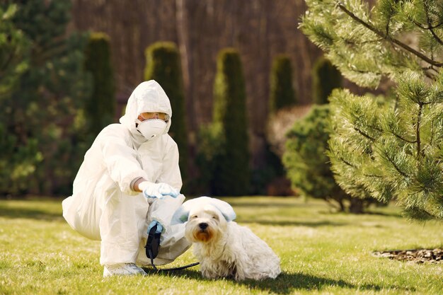 Frau in einem Schutzanzug, der mit einem Hund geht