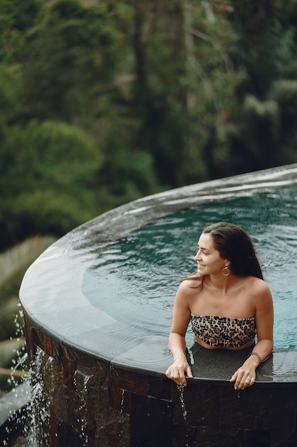 Frau in einem schwimmbad auf einer dschungelansicht