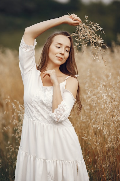 Frau in einem Sommerfeld. Brünette in einem weißen Kleid.