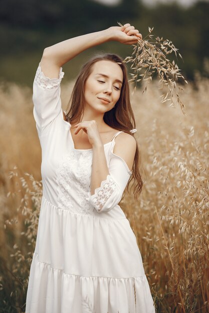 Frau in einem Sommerfeld. Brünette in einem weißen Kleid.