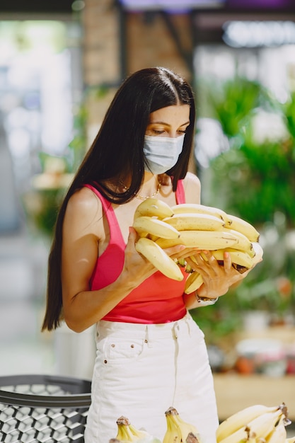 Frau in einem Supermarkt. Dame in einem Beatmungsgerät. Mädchen macht Parchases.