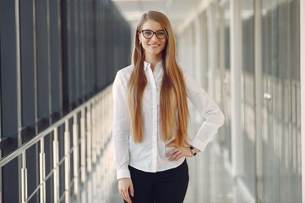 Frau in einer Brille, die im Büro steht