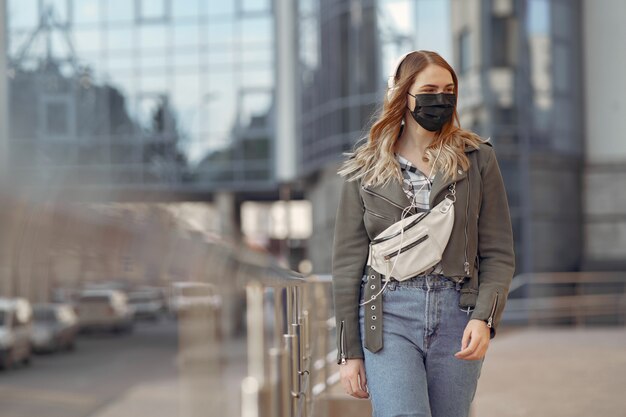 Frau in einer Maske steht auf der Straße