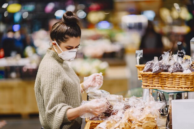 Frau in einer Schutzmaske in einem Supermarkt