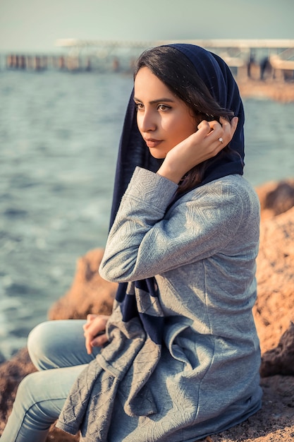 Frau in Hijab-Outfits am Meer