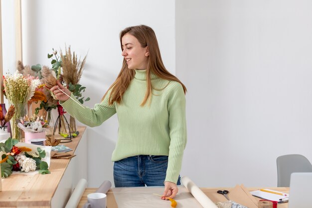 Frau in ihrem Blumenladen mittlerer Schuss