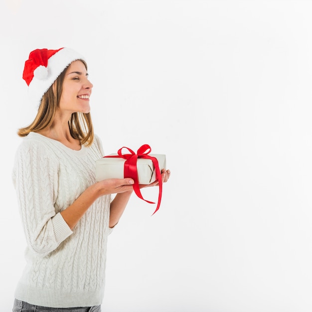 Frau in Sankt-Hut, der mit Geschenkbox steht