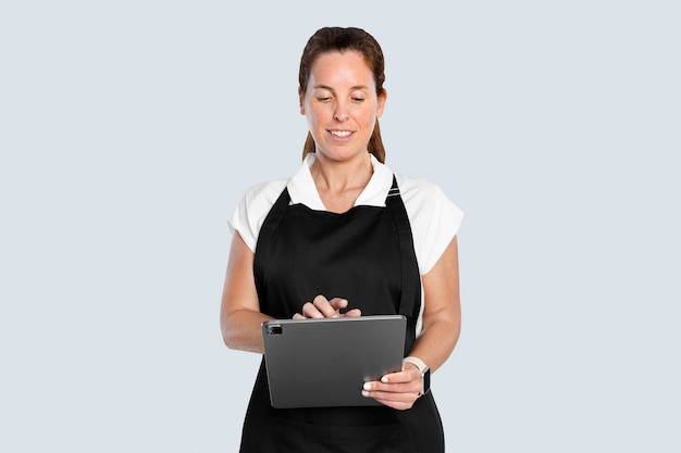 Frau in Schürze mit Tablet