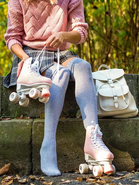 Frau in Socken mit Rollschuhen und Rucksack