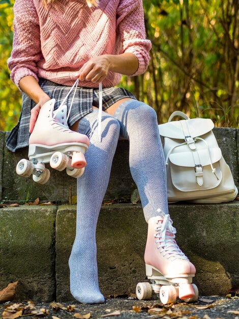 Frau in Socken mit Rollschuhen und Rucksack