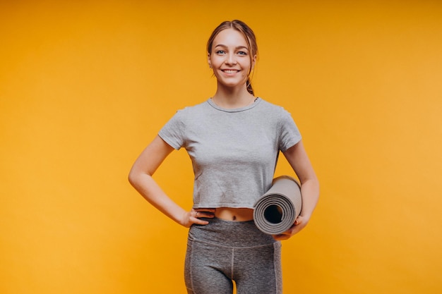 Frau in Sportkleidung mit Matte