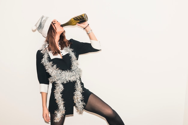 Frau in trinkendem Champagner des Sankt-Hutes von der Flasche