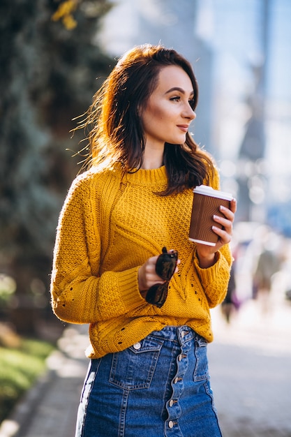 Frau in trinkendem Kaffee der orange Strickjacke