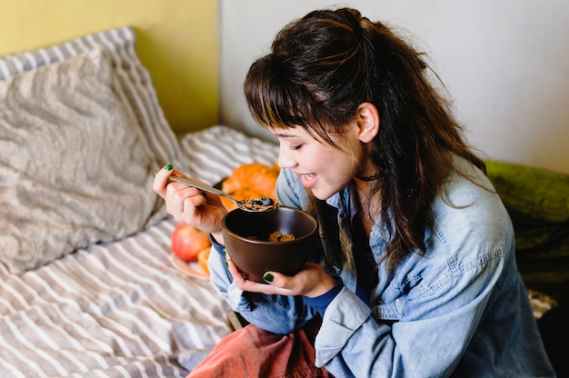 Kostenloses Foto frau isst frühstück auf dem bett