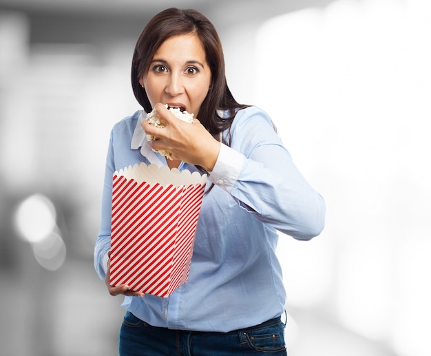 Frau isst Popcorn mit Verlangen