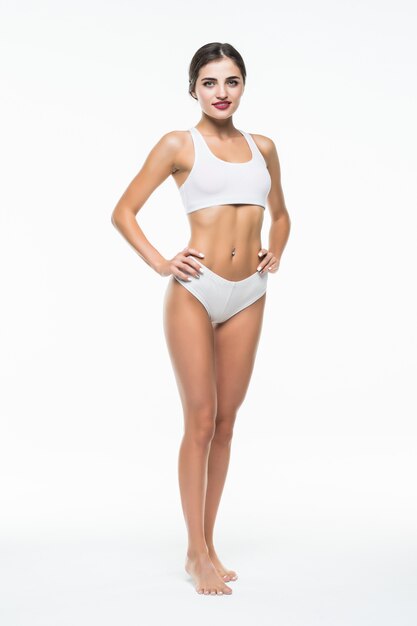 Frau Körperschönheit, schlankes Modell, das in der weißen Unterwäsche geht, lokalisiert über weißer Wand