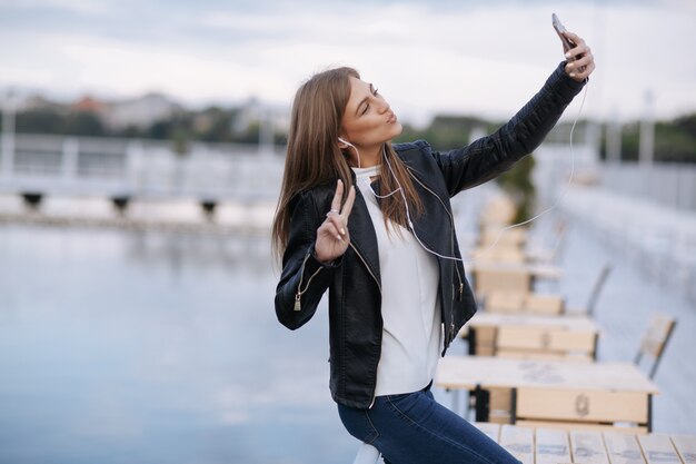 Frau lachend stützte sich auf ein Geländer posiert für ein Foto