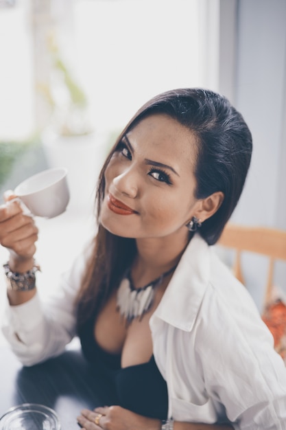 Frau lächelnd mit einer Tasse Kaffee