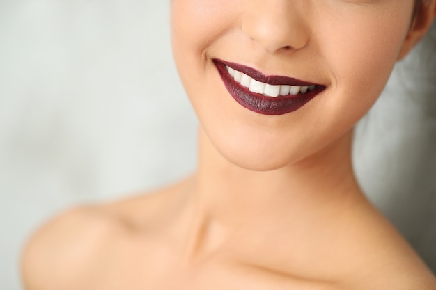 Frau lächelt mit dunkelroten Lippen