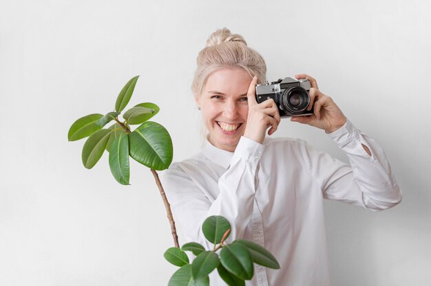 Frau lächelt und hält ein Kamerafotokunstkonzept