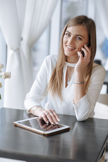 Frau lächelt, während am Telefon sprechen