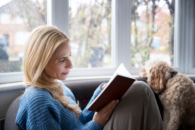 Frau liest ein Buch, während es regnet